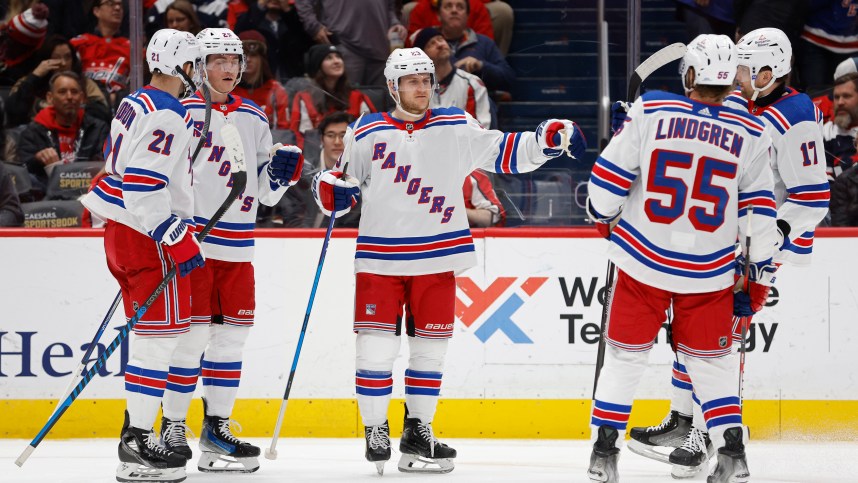 New York Rangers defenseman Adam Fox (23) celebrates with teammates after scoring a goal against the Washington Capitals in the second period at Capital One Arena