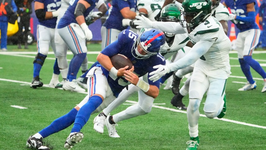 New York Jets safety Jordan Whitehead (3) tackles New York Giants quarterback Tommy DeVito (15) in the fourth quarter at MetLife Stadium