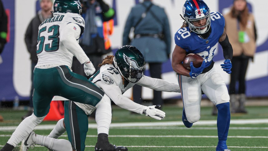 New York Giants running back Eric Gray (20) carries the ball as Philadelphia Eagles cornerback Bradley Roby (33) and linebacker Shaquille Leonard (53) pursue during the second half at MetLife Stadium