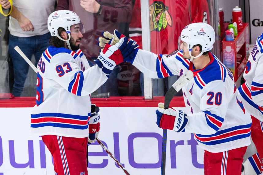New York Rangers center Mika Zibanejad (93) celebrates with center Rem Pitlick (20) against the Chicago Blackhawks after the game at the United Center