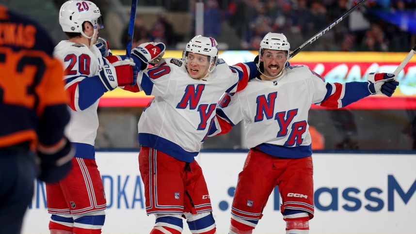 New York Rangers left wing Chris Kreider (20) celebrates his goal against the New York Islanders with left wing Artemi Panarin (10) and center Vincent Trocheck (16) during the third period of a Stadium Series ice hockey game at MetLife Stadium