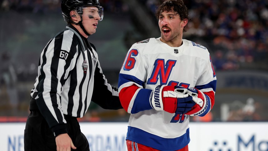New York Rangers center Vincent Trocheck (16) is led off the ice by linesman Libor Suchanek (60) after a roughing call against Trochek and New York Islanders defenseman Alexander Romanov (not pictured) during the third period of a Stadium Series ice hockey game at MetLife Stadium