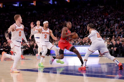 Chicago Bulls guard Ayo Dosunmu (12) drives the lane against New York Knicks guards Donte DiVincenzo (0) and Josh Hart (3) and Jalen Brunson (11) during the third quarter at Madison Square Garden