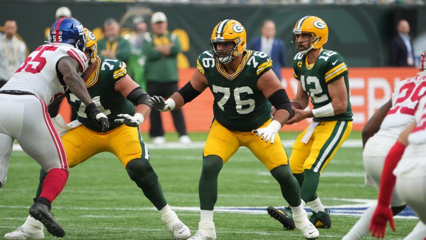 Green Bay Packers guard Jon Runyan (76) blocks as quarterback Aaron Rodgers (12) drops back to pass against the New York Giants during an NFL International Series game at Tottenham Hotspur Stadium