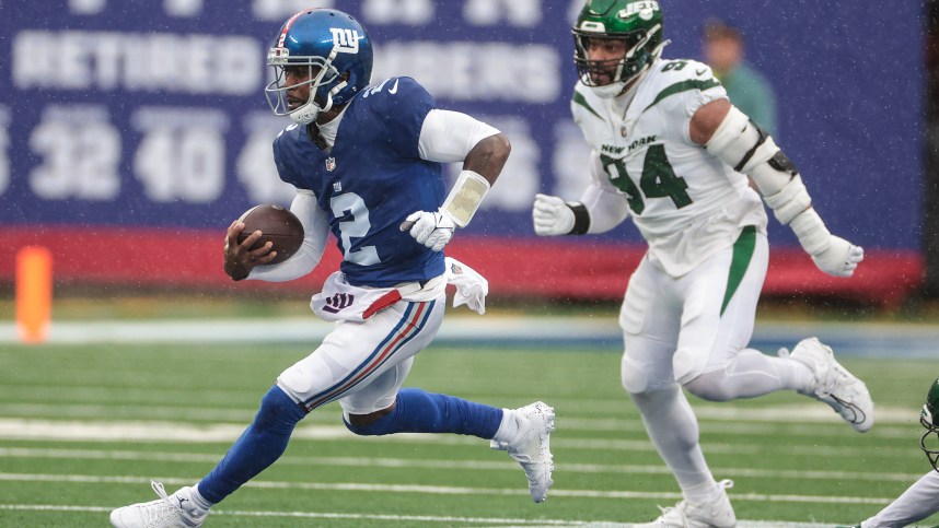 New York Giants quarterback Tyrod Taylor (2) carries the ball in front of New York Jets defensive end Solomon Thomas (94) during the first half at MetLife Stadium