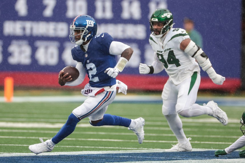 New York Giants quarterback Tyrod Taylor (2) carries the ball in front of New York Jets defensive end Solomon Thomas (94) during the first half at MetLife Stadium