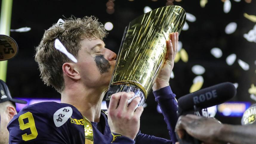 Michigan quarterback J.J. McCarthy kisses the championship trophy to celebrate the Wolverines' 34-13 win over Washington in the national championship game at NRG Stadium in Houston (New York Giants prospect)
