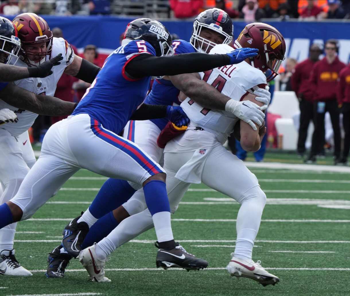 Dexter Lawrence and Kayvon Thibodeaux of the Giants sack Sam Howell of the Commanders in the first half. The NY Giants host the Washington Commanders at MetLife Stadium
