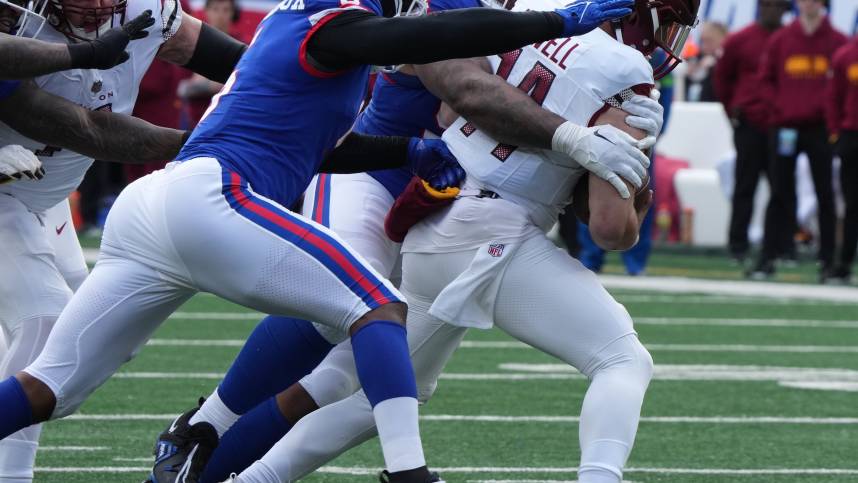 Dexter Lawrence and Kayvon Thibodeaux of the Giants sack Sam Howell of the Commanders in the first half. The NY Giants host the Washington Commanders at MetLife Stadium