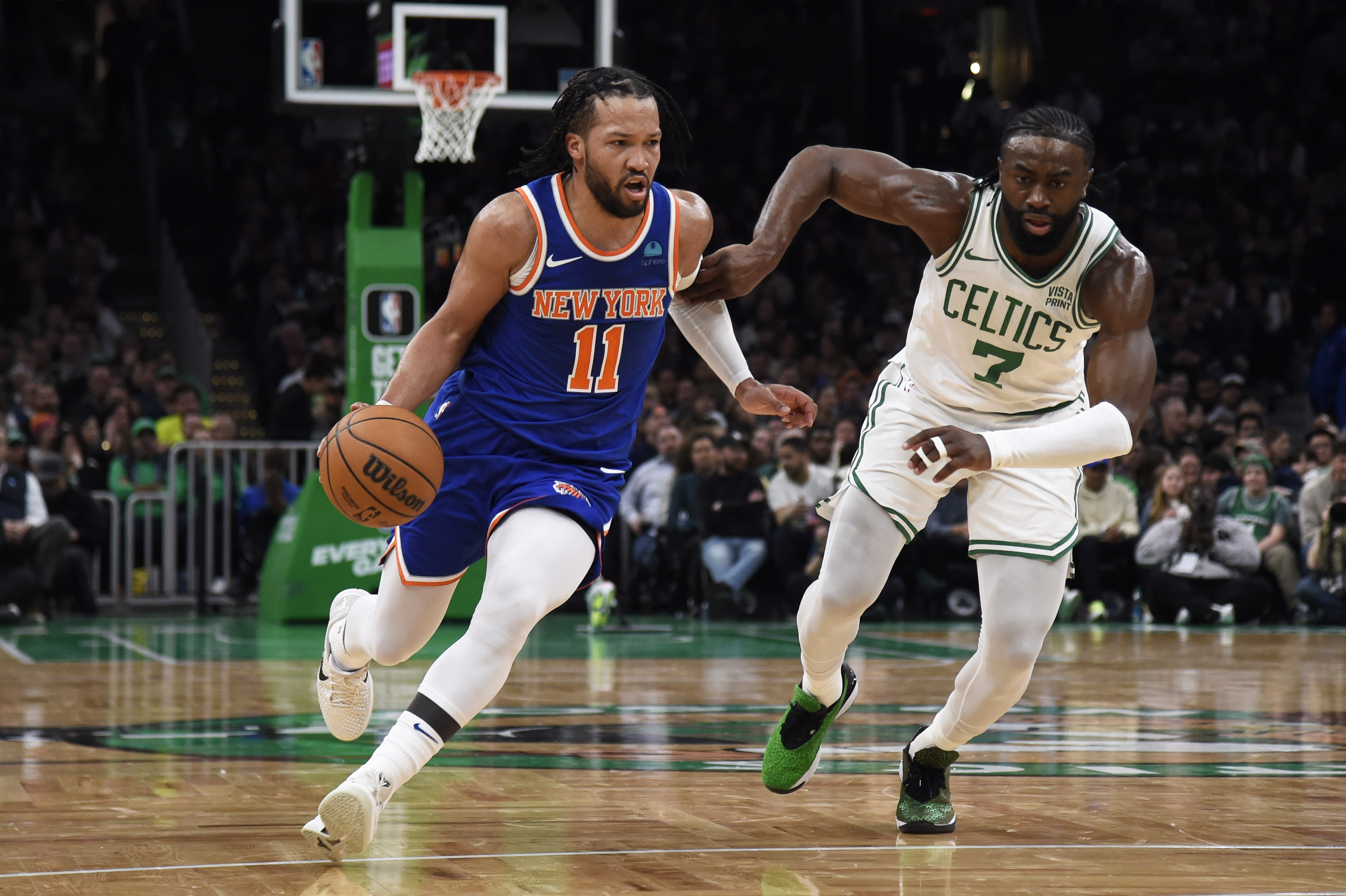 New York Knicks guard Jalen Brunson (11) controls the ball while Boston Celtics guard Jaylen Brown (7) defends during the first half at TD Garden.