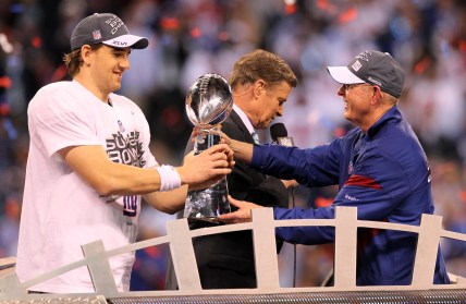 New York Giants head coach Tom Coughlin (right) hands the Vince Lombardi Trophy to quarterback Eli Manning (left) after Super Bowl XLVI against the New England Patriots at Lucas Oil Stadium
