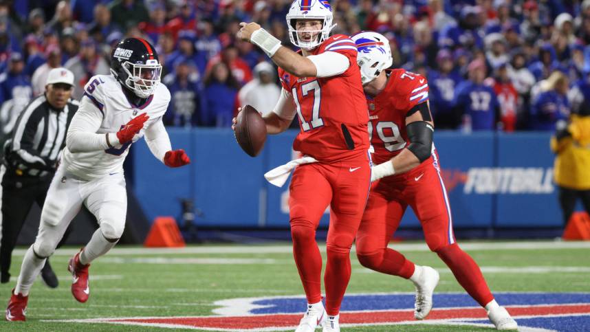 Buffalo Bills quarterback Josh Allen (17) directs his receivers as he is flushes out of the pocket by New York Giants linebacker Kayvon Thibodeaux (5).
