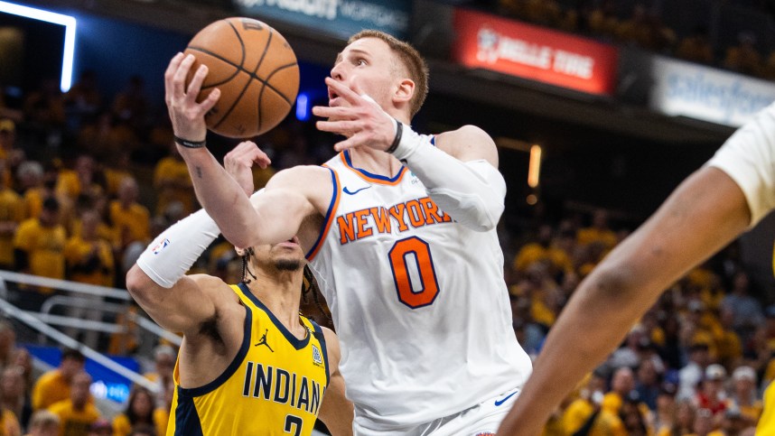 May 17, 2024; Indianapolis, Indiana, USA; New York Knicks guard Donte DiVincenzo (0) shoots the ball while Indiana Pacers guard Andrew Nembhard (2) defends during game six of the second round for the 2024 NBA playoffs at Gainbridge Fieldhouse. Mandatory Credit: Trevor Ruszkowski-USA TODAY Sports