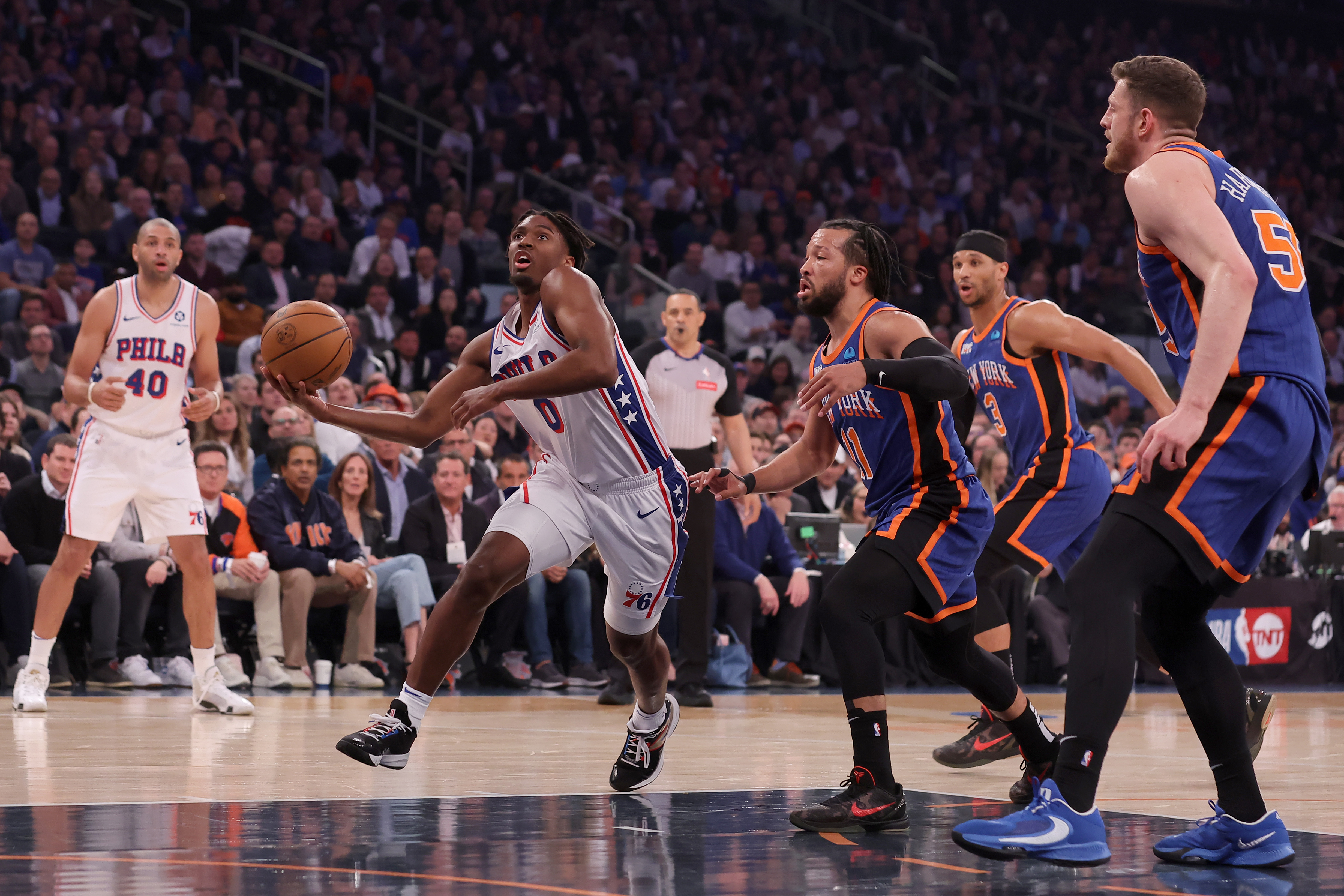 Apr 30, 2024; New York, New York, USA; Philadelphia 76ers guard Tyrese Maxey (0) drives to the basket against New York Knicks guards Jalen Brunson (11) and Josh Hart (3) and center Isaiah Hartenstein (55) during the first quarter of game 5 of the first round of the 2024 NBA playoffs at Madison Square Garden. Mandatory Credit: Brad Penner-USA TODAY Sports