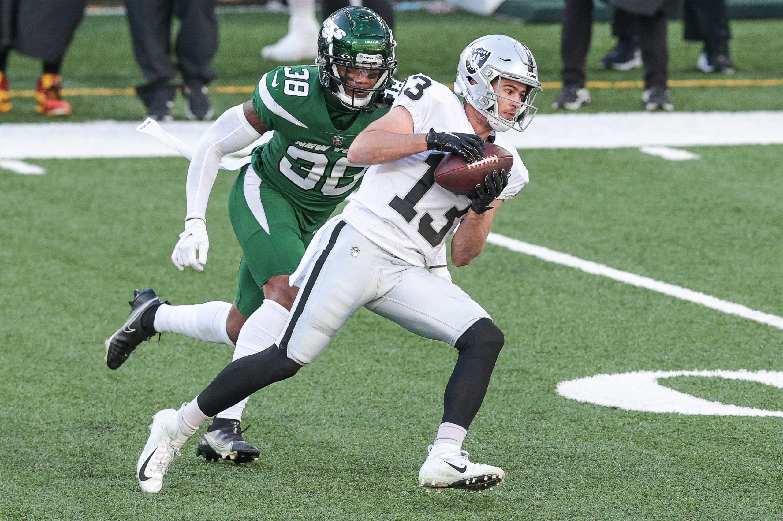 Dec 6, 2020; East Rutherford, New Jersey, USA; Las Vegas Raiders wide receiver Hunter Renfrow (13) catches the ball as New York Jets cornerback Lamar Jackson (38) pursues during the first half at MetLife Stadium. Mandatory Credit: Vincent Carchietta-USA TODAY Sports