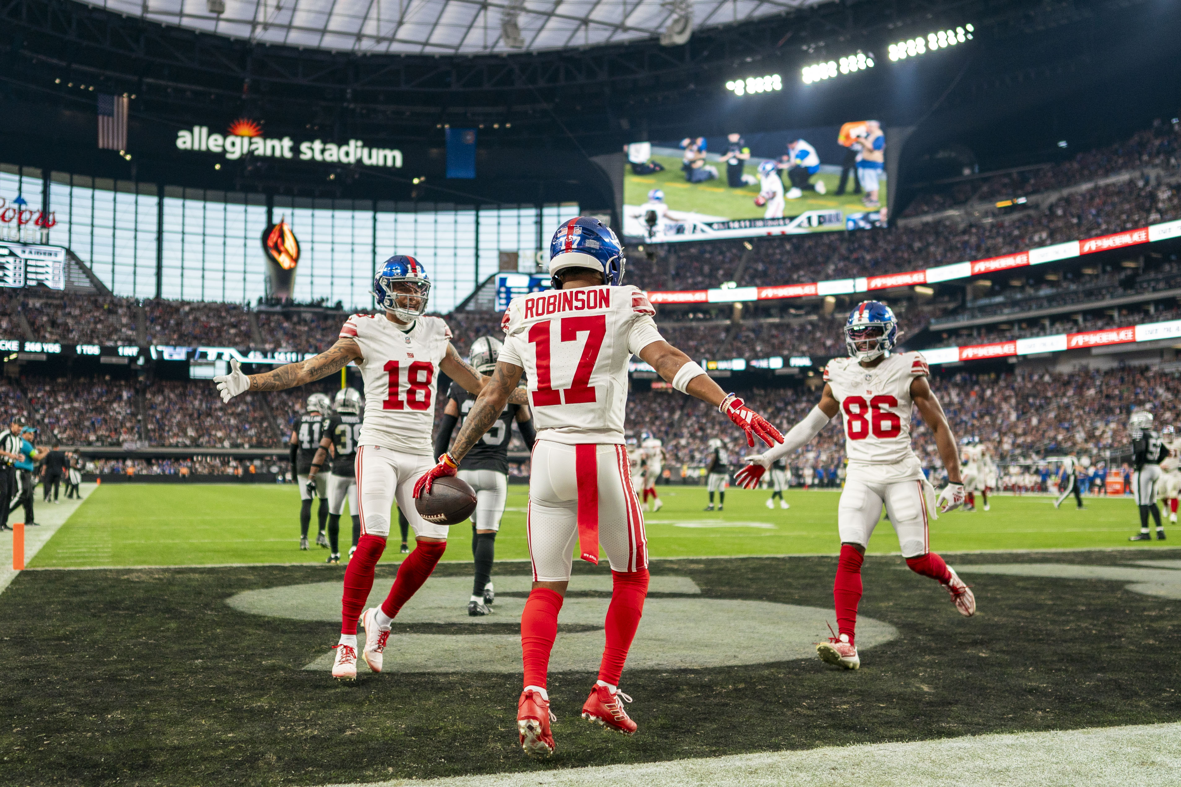 November 5, 2023; Paradise, Nevada, USA; New York Giants wide receiver Wan'Dale Robinson (17) is congratulated by wide receiver Isaiah Hodgins (18) and wide receiver Darius Slayton (86) for scoring a touchdown against the Las Vegas Raiders during the fourth quarter at Allegiant Stadium. Mandatory Credit: Kyle Terada-USA TODAY Sports