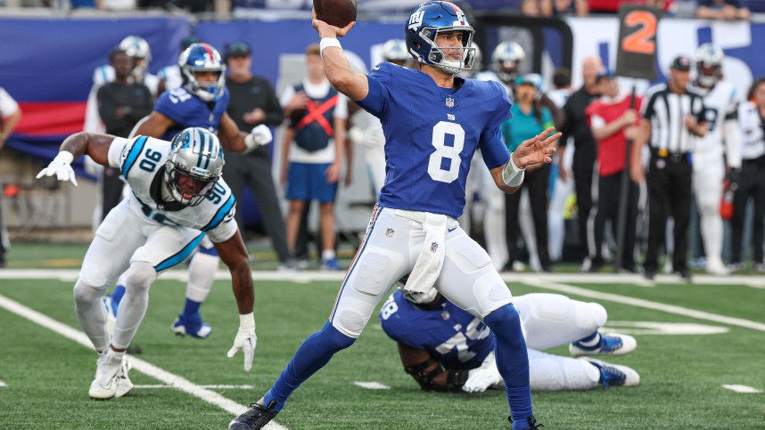 Aug 18, 2023; East Rutherford, New Jersey, USA; New York Giants quarterback Daniel Jones (8) throws the ball during the first quarter as Carolina Panthers linebacker Amare Barno (90) pursues at MetLife Stadium. Mandatory Credit: Vincent Carchietta-USA TODAY Sports