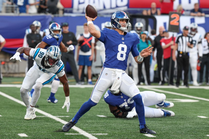 Aug 18, 2023; East Rutherford, New Jersey, USA; New York Giants quarterback Daniel Jones (8) throws the ball during the first quarter as Carolina Panthers linebacker Amare Barno (90) pursues at MetLife Stadium. Mandatory Credit: Vincent Carchietta-USA TODAY Sports
