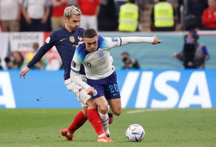 Dec 10, 2022; Al Khor, Qatar; England midfielder Phil Foden (Manchester City) (20) and France forward Antoine Griezmann (7) battle for the ball during the first half of a quarterfinal game in the 2022 FIFA World Cup at Al-Bayt Stadium. Mandatory Credit: Yukihito Taguchi-USA TODAY Sports