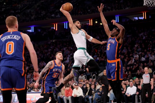 Feb 24, 2024; New York, New York, USA; Boston Celtics forward Jayson Tatum (0) drives to the basket against New York Knicks forward Precious Achiuwa (5) and center Isaiah Hartenstein (55) and guard Donte DiVincenzo (0) during the first quarter at Madison Square Garden. Mandatory Credit: Brad Penner-USA TODAY Sports