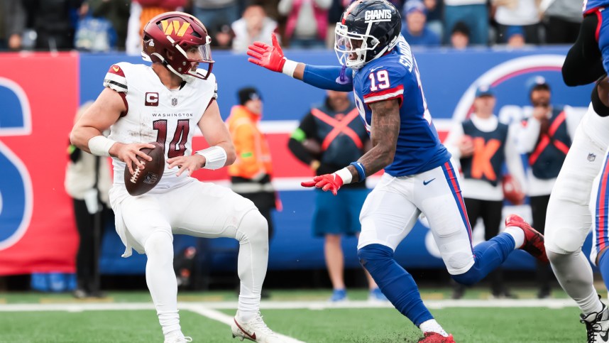 Oct 22, 2023; East Rutherford, New Jersey, USA; Washington Commanders quarterback Sam Howell (14) is pressured by New York Giants safety Isaiah Simmons (19) during the fourth quarter at MetLife Stadium. Mandatory Credit: Vincent Carchietta-USA TODAY Sports