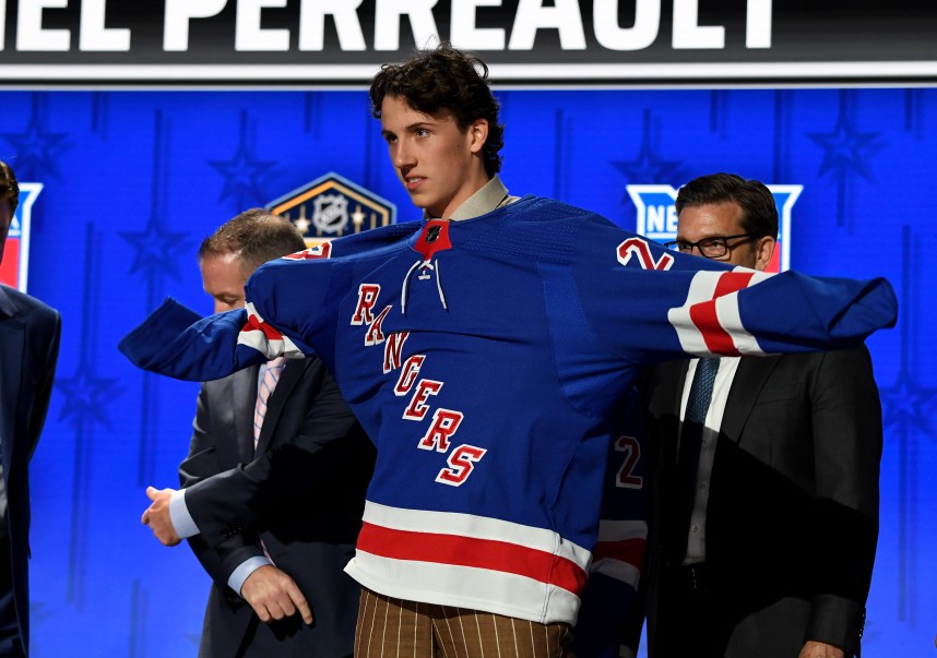Jun 28, 2023; Nashville, Tennessee, USA; New York Rangers draft pick Gabriel Perreault puts on his sweater after being selected with the twenty third pick in round one of the 2023 NHL Draft at Bridgestone Arena. Mandatory Credit: Christopher Hanewinckel-USA TODAY Sports
