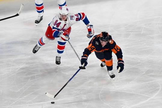 Feb 18, 2024; East Rutherford, New Jersey, USA;  New York Islanders center Bo Horvat (14) and New York Rangers center Adam Edstrom (84)  chase a loose puck during the third period in a Stadium Series ice hockey game at MetLife Stadium. Mandatory Credit: Dennis Schneidler-USA TODAY Sports