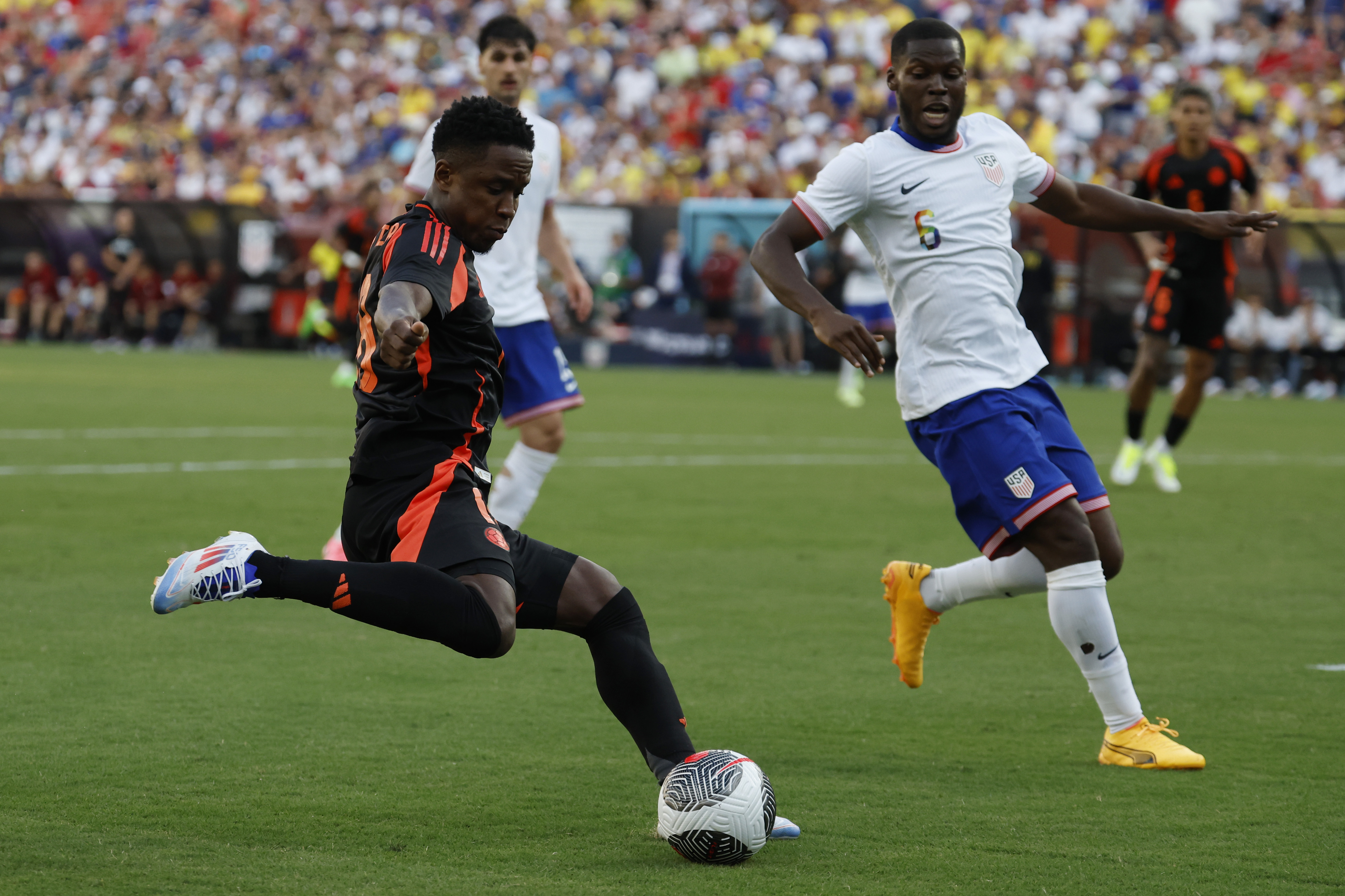 Jun 8, 2024; Landover, Maryland, USA; Colombia forward Rafael Santtos Borre (19) crosses the ball as United States defender Antonee Robinson (5) defends in the second half at Commanders Field. Mandatory Credit: Geoff Burke-USA TODAY Sports