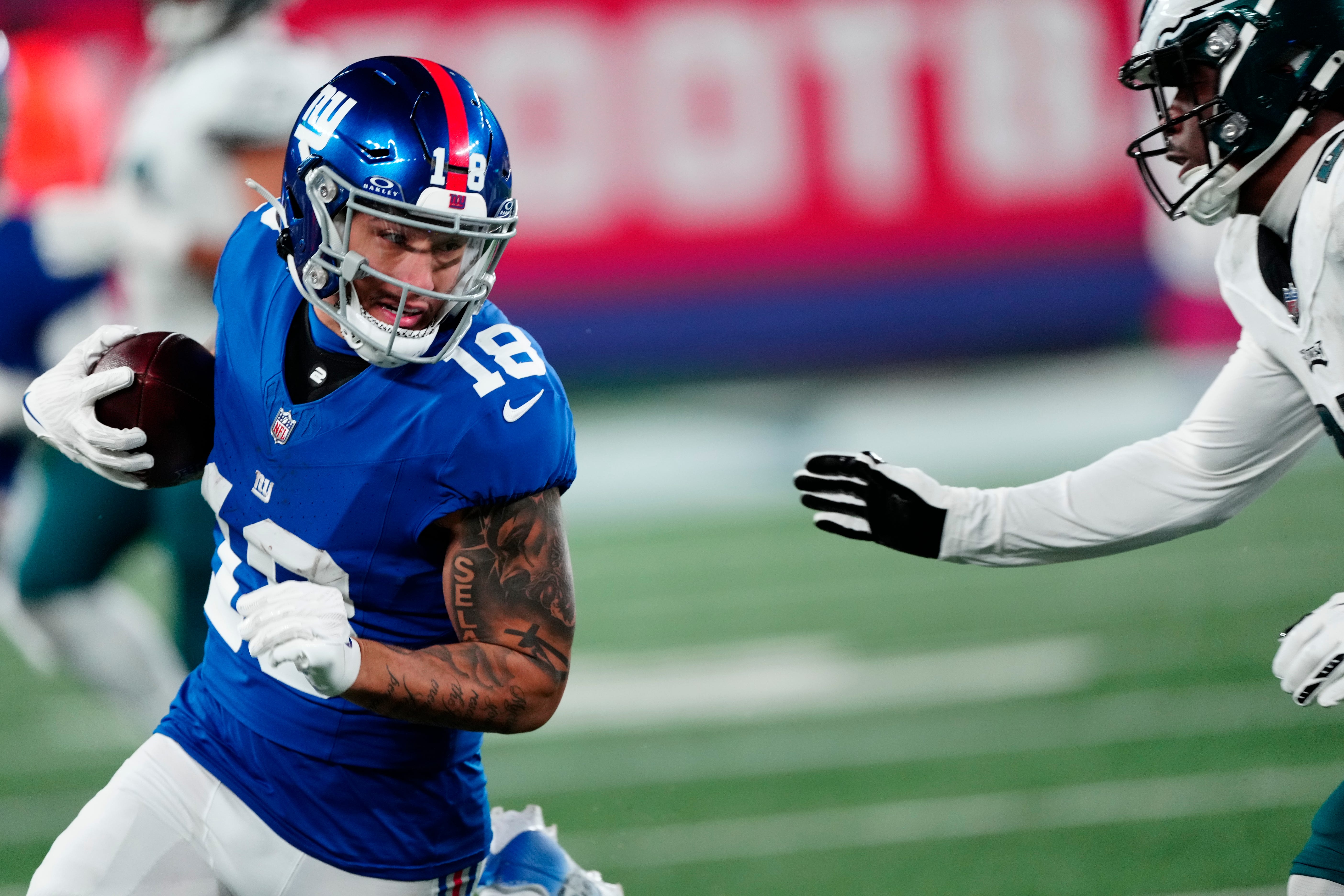 New York Giants wide receiver Isaiah Hodgins (18) tries to avoid Philadelphia Eagles cornerback Kelee Ringo (22), Sunday, January 7, 2024.