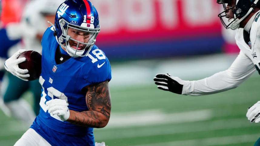 New York Giants wide receiver Isaiah Hodgins (18) tries to avoid Philadelphia Eagles cornerback Kelee Ringo (22), Sunday, January 7, 2024.