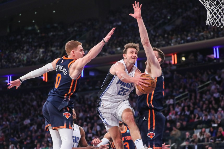 Mar 8, 2024; New York, New York, USA;  Orlando Magic forward Franz Wagner (22) drives in between New York Knicks guard Donte DiVincenzo (0) and center Isaiah Hartenstein (55) in the first quarter at Madison Square Garden. Mandatory Credit: Wendell Cruz-USA TODAY Sports