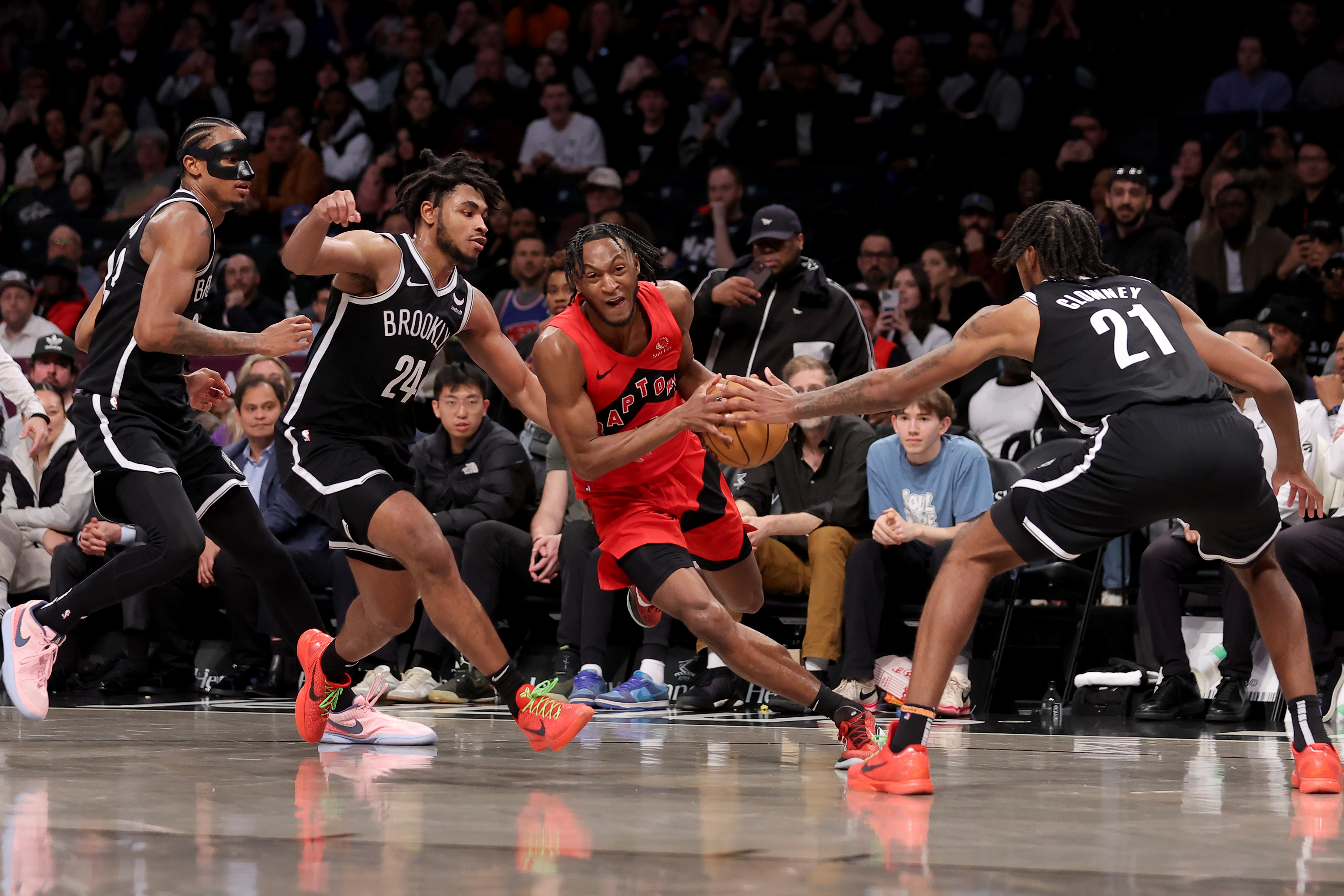 Apr 10, 2024; Brooklyn, New York, USA; Toronto Raptors guard Immanuel Quickley (5) drives to the basket against Brooklyn Nets center Nic Claxton (33) and guard Cam Thomas (24) and forward Noah Clowney (21) during the fourth quarter at Barclays Center. Mandatory Credit: Brad Penner-USA TODAY Sports