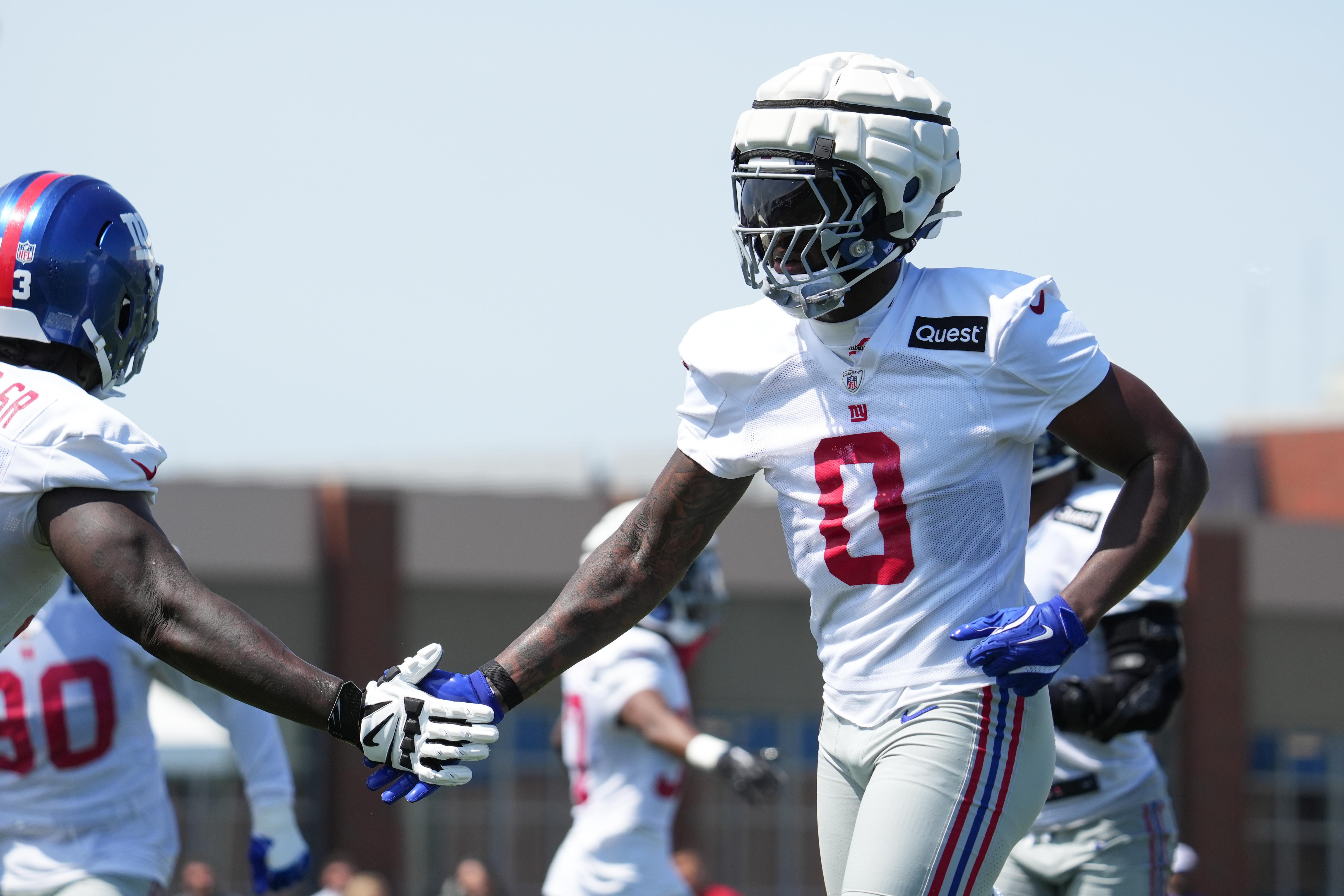 Jul 26, 2024; East Rutherford, NJ, USA; New York Giants linebacker Brian Burns (0) high fives New York Giants defensive tackle Rakeem Nunez-Roches (93) during training camp at Quest Diagnostics Training Center. Mandatory Credit: Lucas Boland-USA TODAY Sports