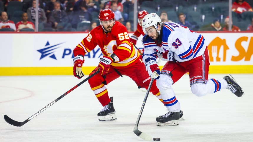 Oct 24, 2023; Calgary, Alberta, CAN; New York Rangers center Mika Zibanejad (93) and Calgary Flames defenseman MacKenzie Weegar (52) battle for the puck during the third period at Scotiabank Saddledome. Mandatory Credit: Sergei Belski-USA TODAY Sports