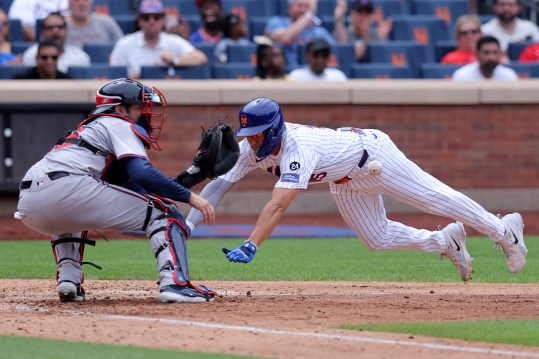 Jul 28, 2024; New York City, New York, USA; Atlanta Braves catcher Travis d'Arnaud (16) waits for the ball before tagging out New York Mets center fielder Tyrone Taylor (15) trying to score from second base on a single by New York Mets left fielder Ben Gamel (not pictured) during the fifth inning at Citi Field. Mandatory Credit: Brad Penner-USA TODAY Sports