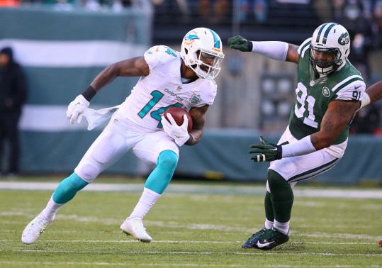 Nov 29, 2015; East Rutherford, NJ, USA; Miami Dolphins wide receiver Jarvis Landry (14) tries to avoid New York Jets defensive end Sheldon Richardson (91) after catching a pass during the second half at MetLife Stadium.  The Jets defeated the Dolphins 38-20.  Mandatory Credit: Ed Mulholland-USA TODAY Sports