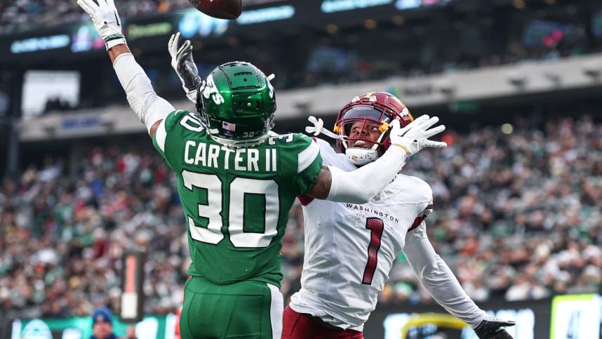 Dec 24, 2023; East Rutherford, New Jersey, USA; New York Jets cornerback Michael Carter II (30) breaks up a pass intended for Washington Commanders wide receiver Jahan Dotson (1) during the second half at MetLife Stadium. Mandatory Credit: Vincent Carchietta-USA TODAY Sports