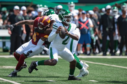 Aug 10, 2024; East Rutherford, New Jersey, USA; New York Jets quarterback Tyrod Taylor (2) looks to pass as Washington Commanders linebacker Frankie Luvu (4) defends during the first quarter at MetLife Stadium. Mandatory Credit: Vincent Carchietta-USA TODAY Sports