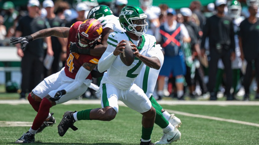 Aug 10, 2024; East Rutherford, New Jersey, USA; New York Jets quarterback Tyrod Taylor (2) looks to pass as Washington Commanders linebacker Frankie Luvu (4) defends during the first quarter at MetLife Stadium. Mandatory Credit: Vincent Carchietta-USA TODAY Sports