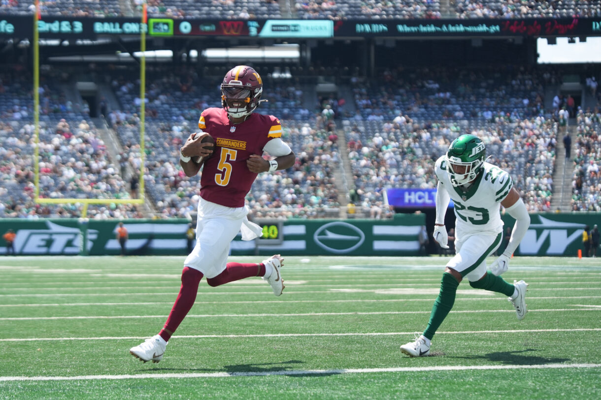 Aug 10, 2024; East Rutherford, New Jersey, USA; Washington Commanders quarterback Jayden Daniels (5) rushes for a touchdown during the first quarter against the New York Jets at MetLife Stadium. Mandatory Credit: Lucas Boland-USA TODAY Sports