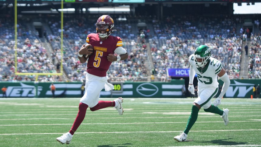 Aug 10, 2024; East Rutherford, New Jersey, USA; Washington Commanders quarterback Jayden Daniels (5) rushes for a touchdown during the first quarter against the New York Jets at MetLife Stadium. Mandatory Credit: Lucas Boland-USA TODAY Sports