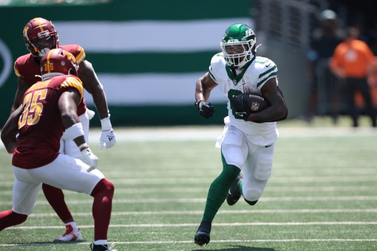 Aug 10, 2024; East Rutherford, New Jersey, USA; New York Jets running back Braelon Allen (0) carries the ball during the first half as Washington Commanders safety Percy Butler (35) defends at MetLife Stadium. Mandatory Credit: Vincent Carchietta-USA TODAY Sports