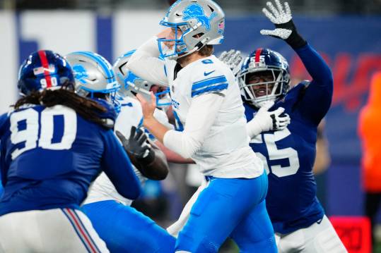 Detroit Lions quarterback Nate Sudfeld (8) gets ready to throw the ball as New York Giants linebacker Boogie Basham (55) tries to prevent the pass, Thursday, August 8 2024, in East Rutherford.