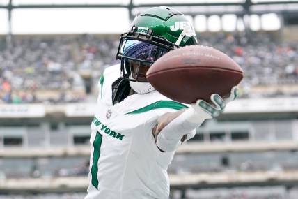 New York Jets cornerback Sauce Gardner (1) catches the ball during warmups before a game against the New England Patriots.