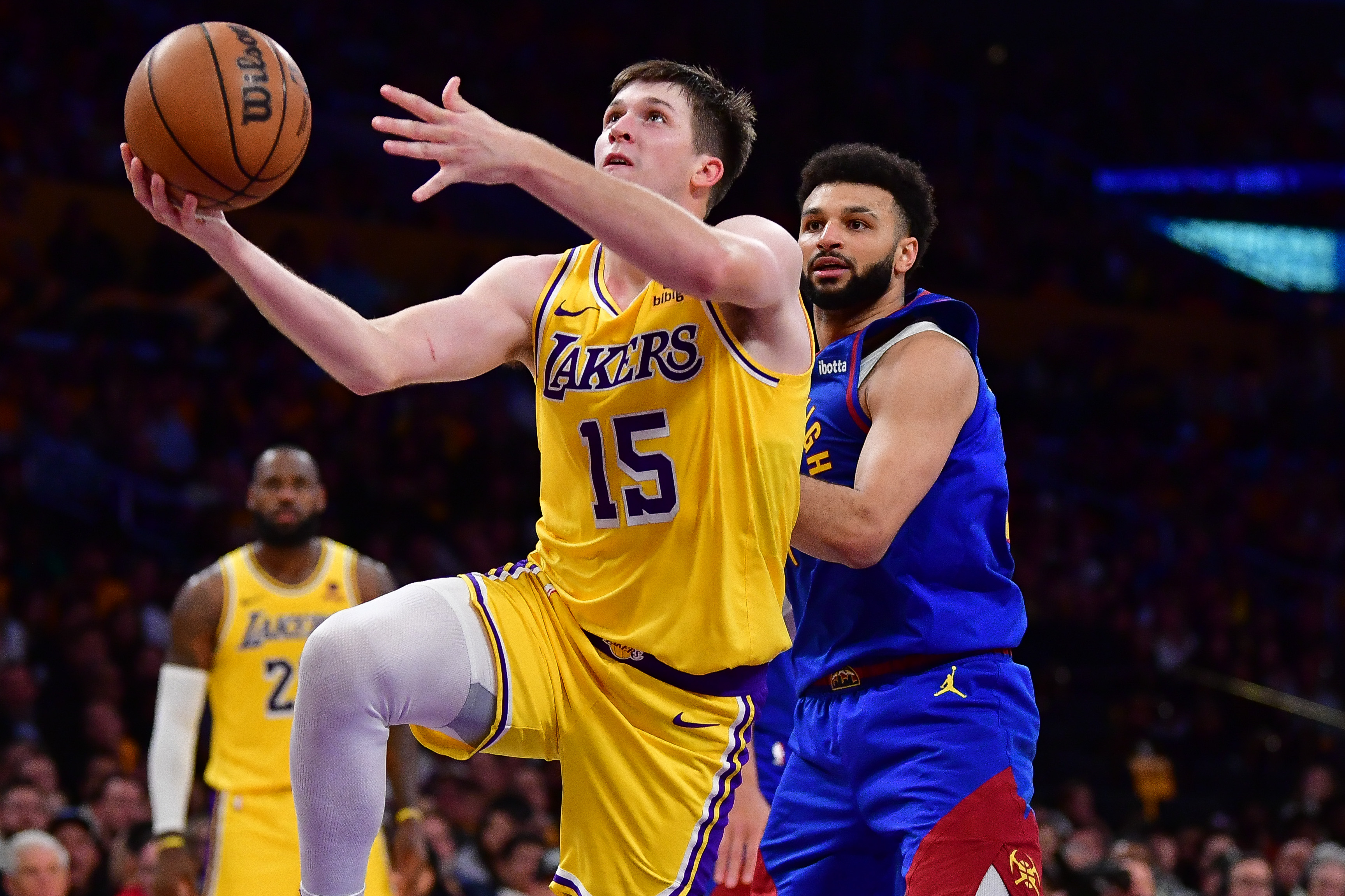 Apr 25, 2024; Los Angeles, California, USA; Los Angeles Lakers guard Austin Reaves (15) shoots ahead of Denver Nuggets guard Jamal Murray (27) during the second half in game three of the first round for the 2024 NBA playoffs at Crypto.com Arena. Mandatory Credit: Gary A. Vasquez-Imagn Images