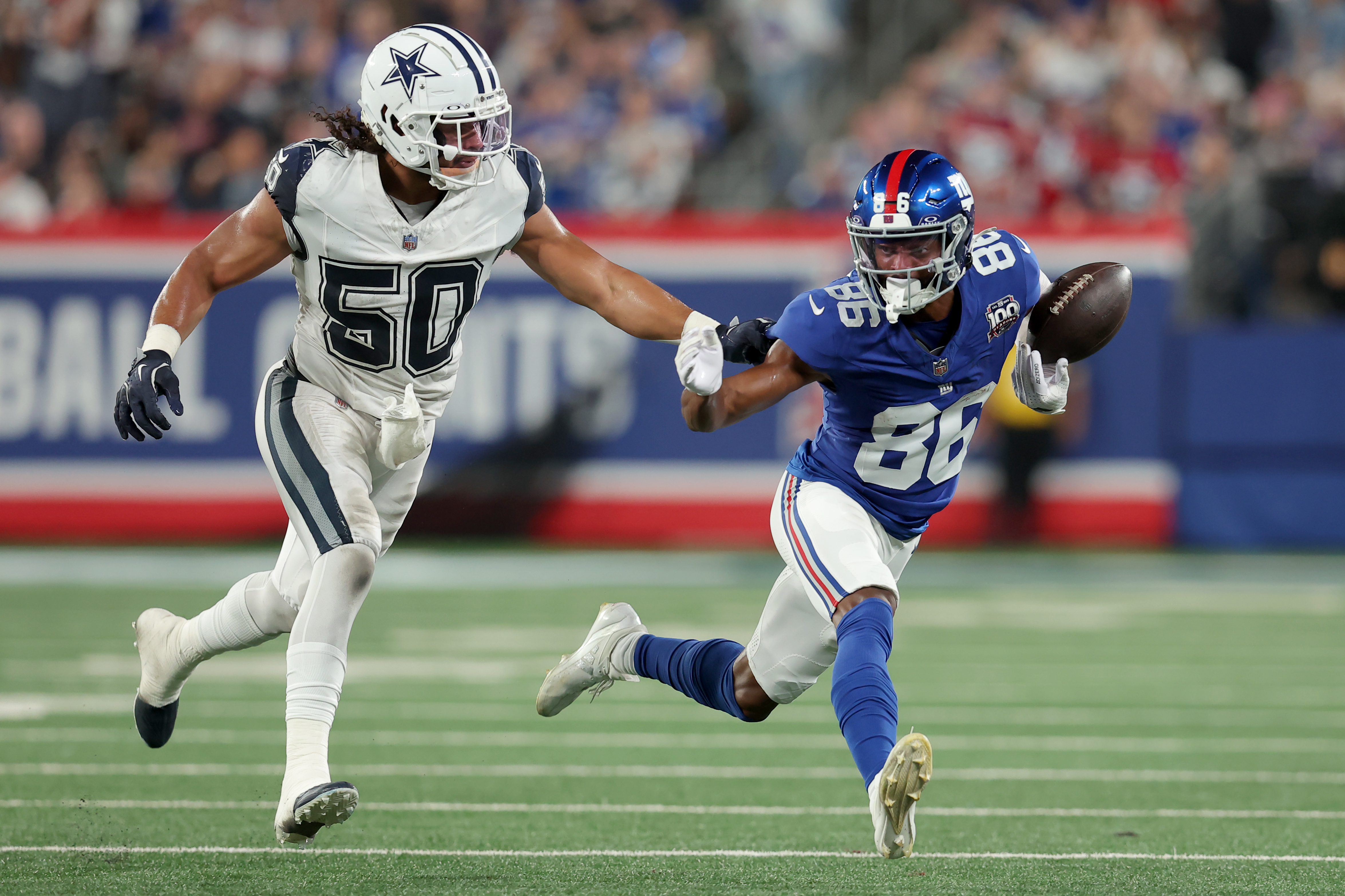 Sep 26, 2024; East Rutherford, New Jersey, USA; New York Giants wide receiver Darius Slayton (86) bobbles the ball as he runs against Dallas Cowboys linebacker Eric Kendricks (50) during the second quarter at MetLife Stadium. Mandatory Credit: Brad Penner-Imagn Images