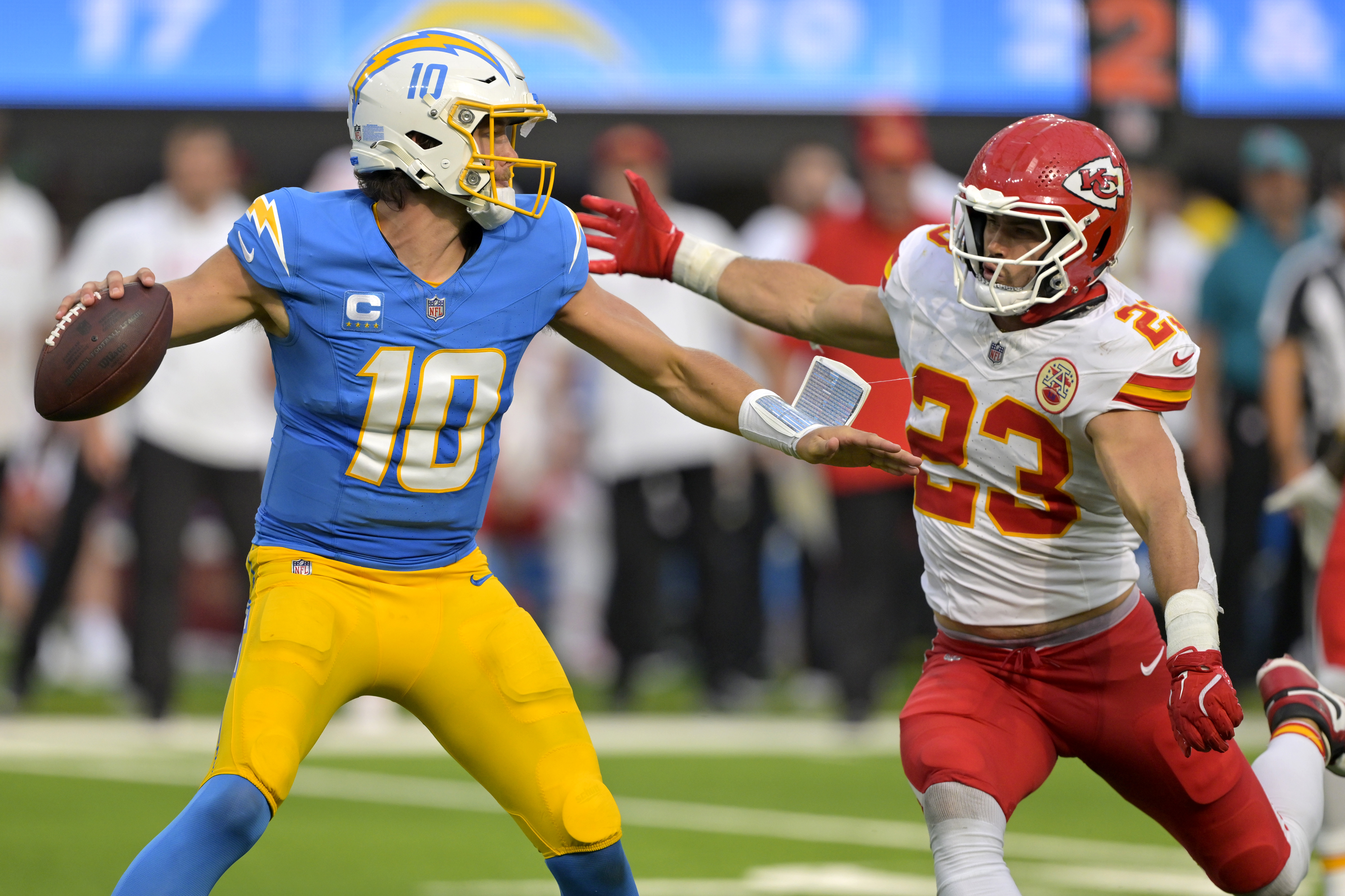 Sep 29, 2024; Inglewood, California, USA;  Los Angeles Chargers quarterback Justin Herbert (10) throws an incomplete pas as is pressured by Kansas City Chiefs linebacker Drue Tranquill (23) at SoFi Stadium. Mandatory Credit: Jayne Kamin-Oncea-Imagn Images