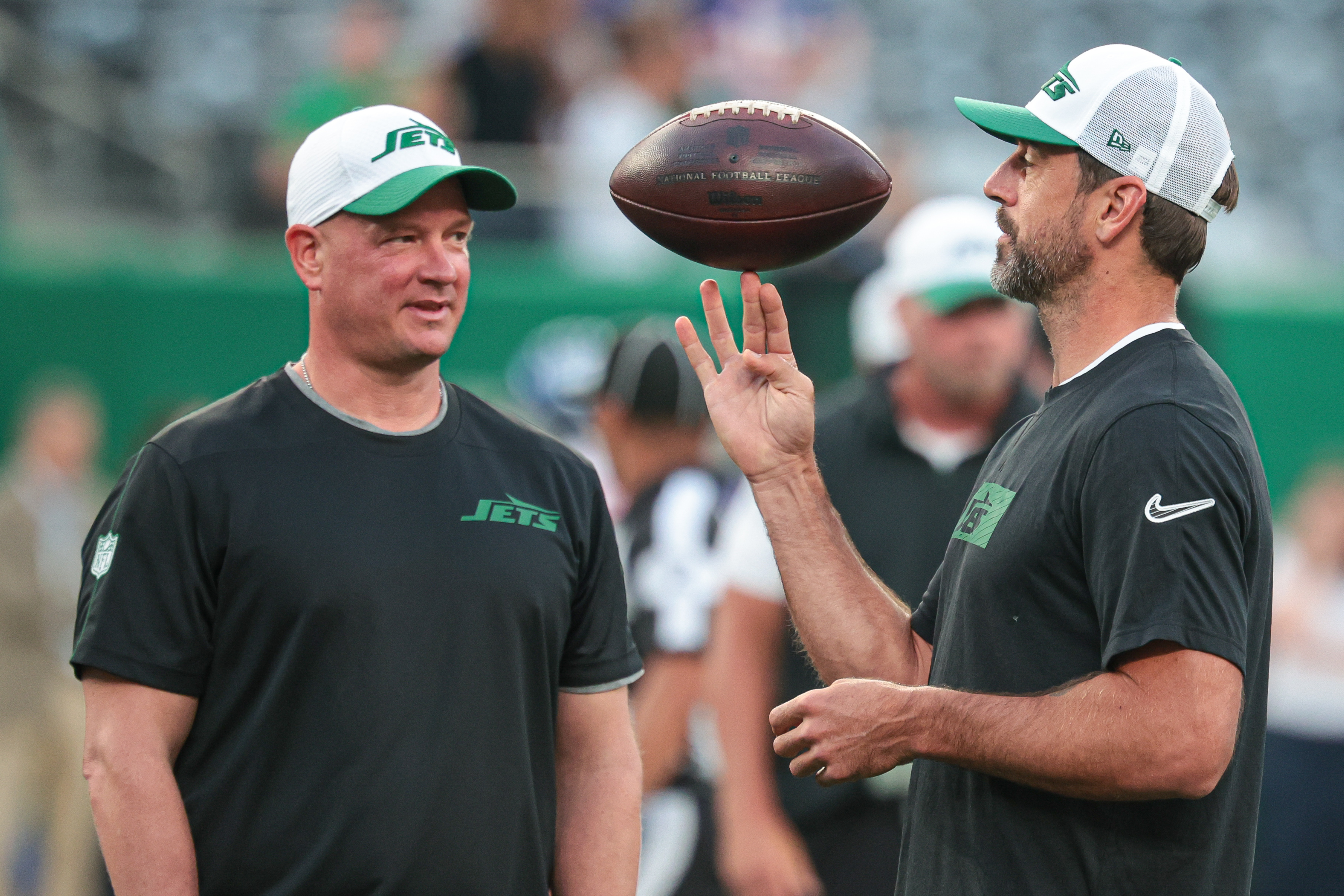 Aug 24, 2024; East Rutherford, New Jersey, USA; New York Jets quarterback Aaron Rodgers (left) spins the ball in front of offensive coordinator Nathaniel Hackett before the game against the New York Giants at MetLife Stadium. Mandatory Credit: Vincent Carchietta-Imagn Images