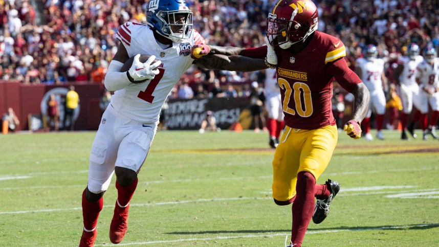 September 15, 2024; Landover, Maryland, USA; New York Giants wide receiver Malik Nabers (1) gives Washington Commanders safety Quan Martin (20) the stiff arm during the second half at Commanders Field. Mandatory Photo Credit: Luke Johnson-Imagn Images