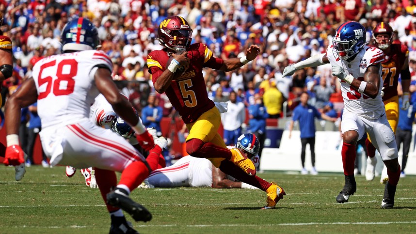 Sep 15, 2024; Landover, Maryland, USA; Washington Commanders quarterback Jayden Daniels (5) runs the ball against New York Giants safety Tyler Nubin (31) and linebacker Bobby Okereke (58) during the fourth quarter at Commanders Field. Mandatory Credit: Peter Casey-Imagn Images